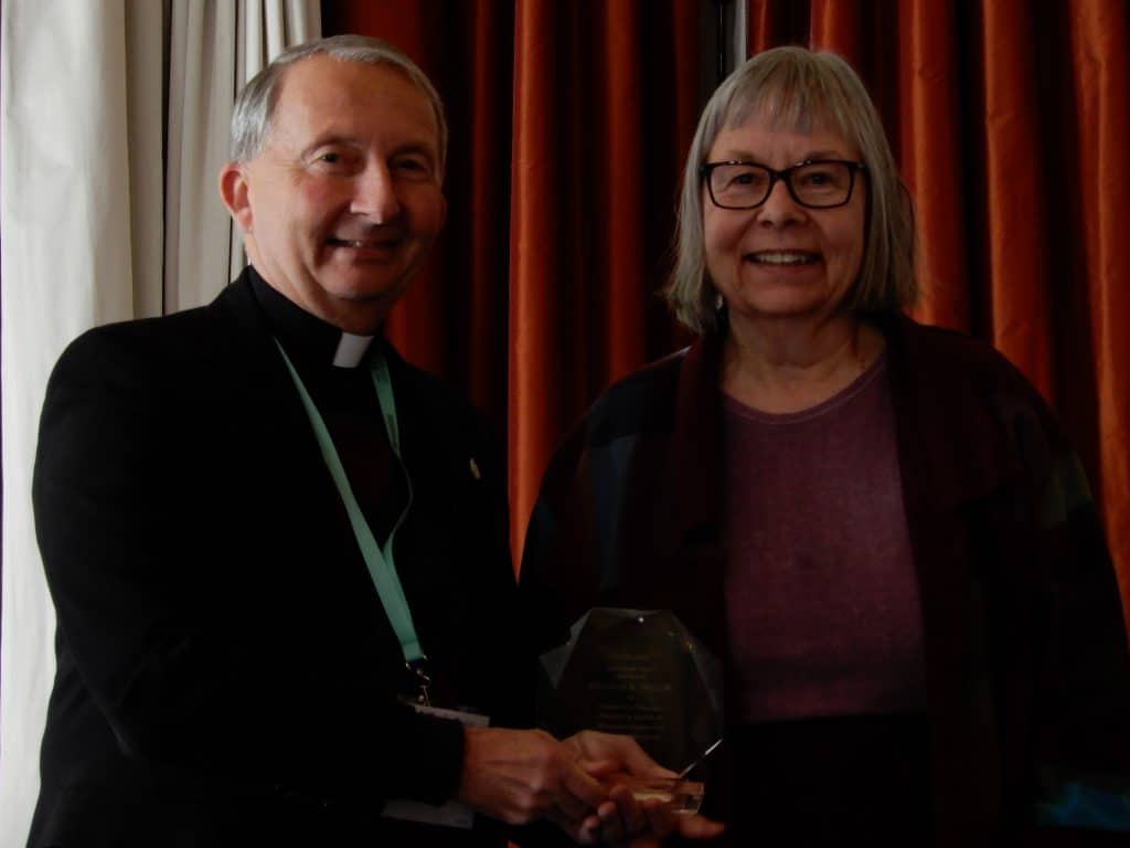 Anne Klejment accepts her award from ACHA president Richard Gribble, C.S.C.